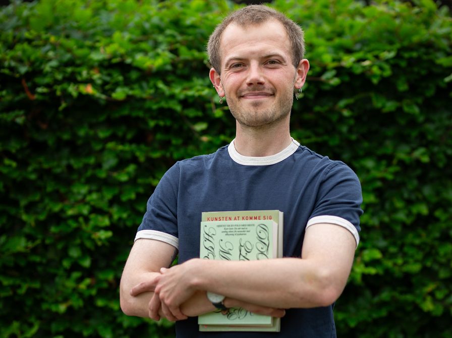 Bibliotekets litteraturformidler Stinus holder en bog